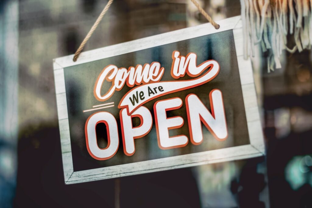 Cartel de Abierto colgado en el escaparate de una tienda